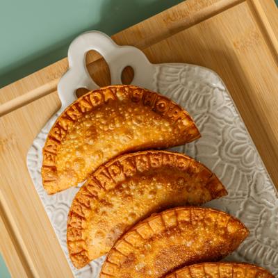 Empanadas arranged on a decorative ceramic plate.