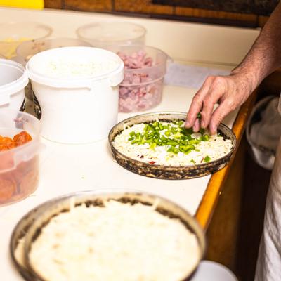 Kitchen staff preparing pizza toppings