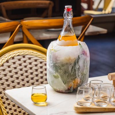 Bottle chilling inside a decorative, fruit-embedded floral ice bucket.