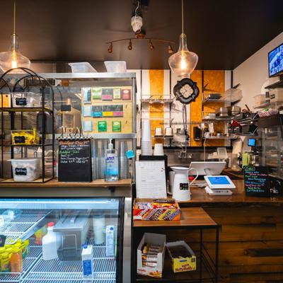 Interior counter area with refrigerated display case and a small chalkboard menu.