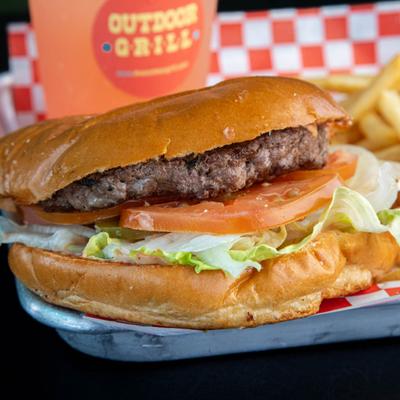 Hamburger with lettuce, tomato and sides of fries and glass of soda.