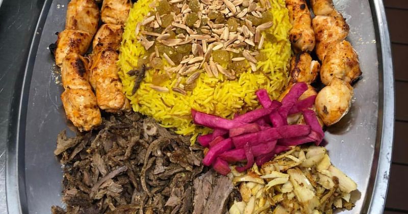 Grilled meats, pickles and yellow rice, clsoeup