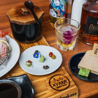 Variety of Japanese condiments and sauces served on the table with bottles of Wiskey.
