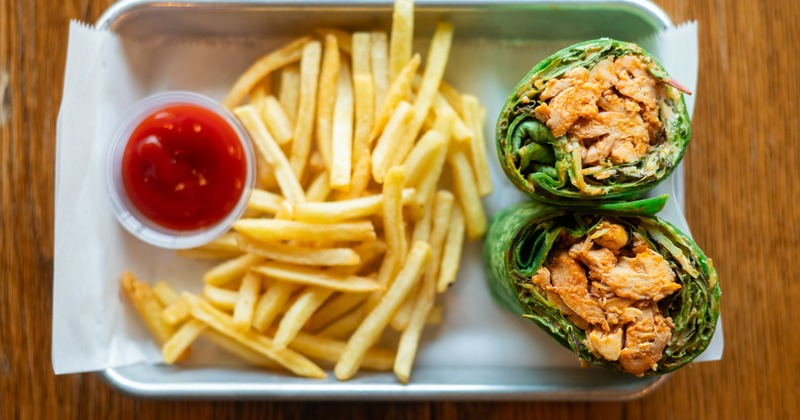 Buffalo chicken Caesar wrap with fries and ketchup