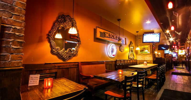 Interior seating area with tables and chairs, lots of decorations, big tv screen