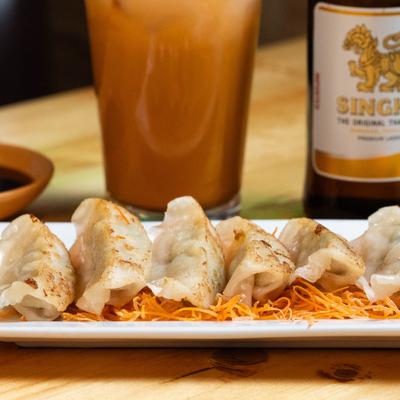 Pan fried dumplings on a bed of shredded carrot.