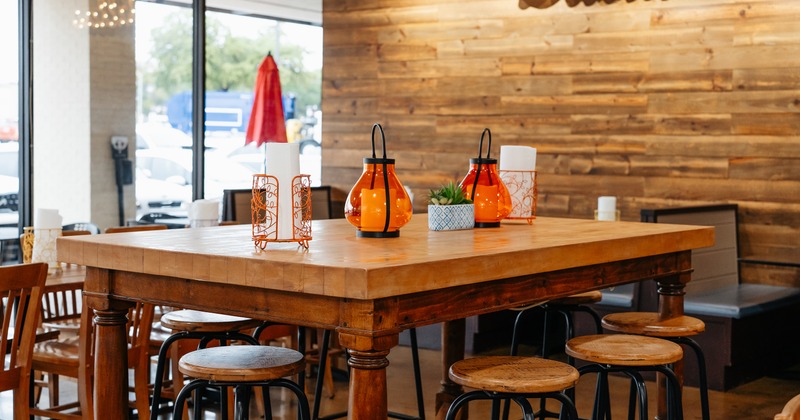 Wooden table with bar stools ready for guests