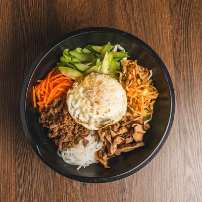 Bibimbap dish with ground meat, shiitake mushrooms, shredded carrots and fried egg.