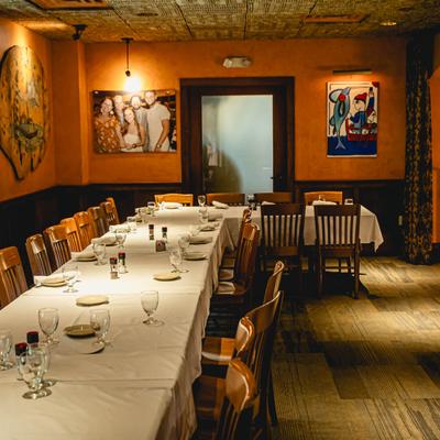 Cozy restaurant interior with a banquet table and wall art.