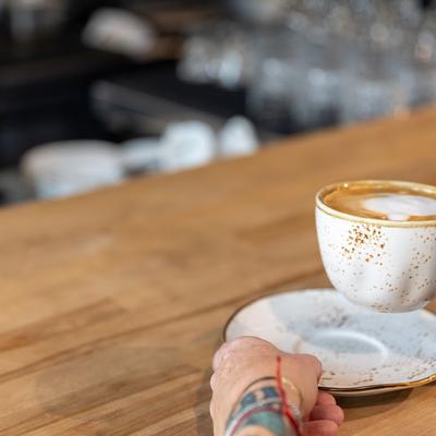 Cup of cappuccino held by a person, closeup