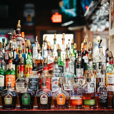 Numerous bottles stacked on the bar.
