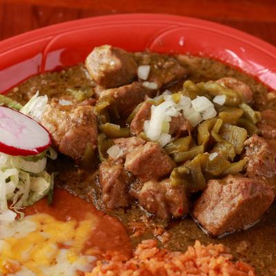 Simmered tender pork with green sauce, onions, sliced peppers, rice and beans