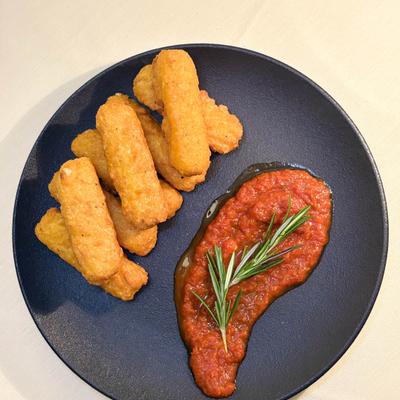 Fried mozzarella sticks with marinara sauce and rosemary garnish.