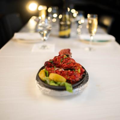 Plate of Tandoori Chicken served on the table with sparkling wine.