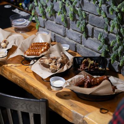 Various dishes on a wooden table against a brick wall.