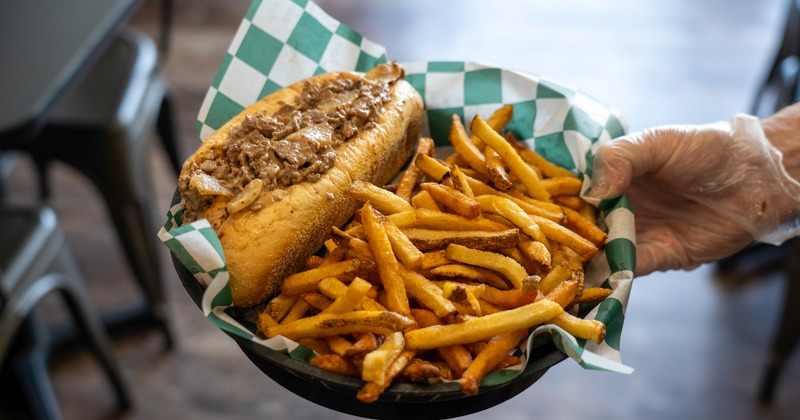 Philly cheesesteak served with a generous side of fries