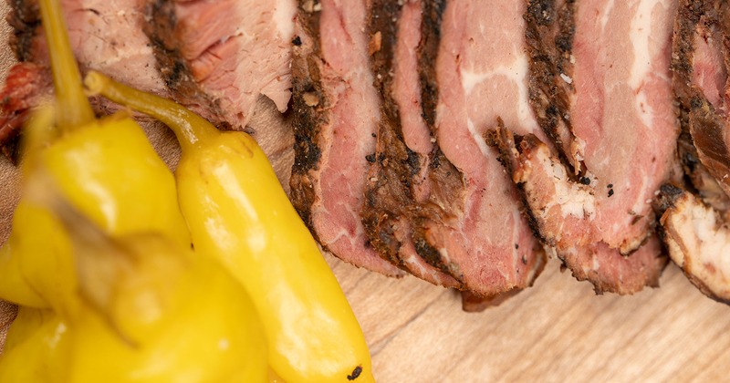 Pieces of meat with peppers on the side, close up