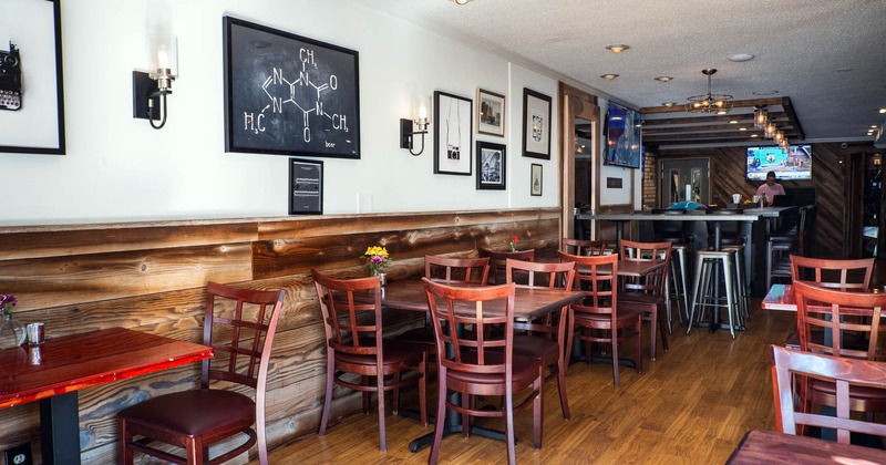 Interior, tables and chairs, vases with flowers on the tables, bar with TV in the back