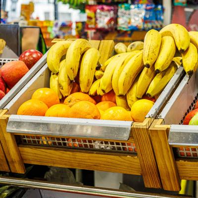 Wooden display bin in a store stocked with fresh fruit.