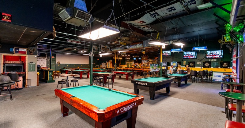 Spacious sports bar interior space with lined-up pool tables