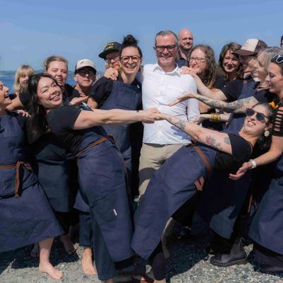 Staff hugging by the shore.