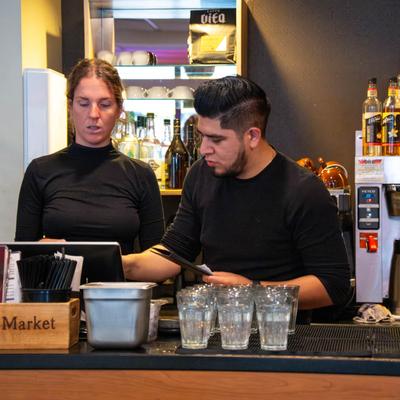 Two bar staff members behind the counter.