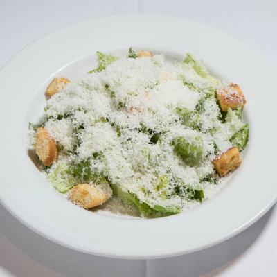 Caesar Salad topped with grated parmigiano-reggiano cheese.
