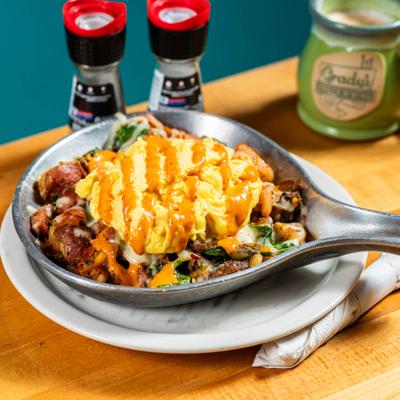 Breakfast skillet with eggs and orange sauce.