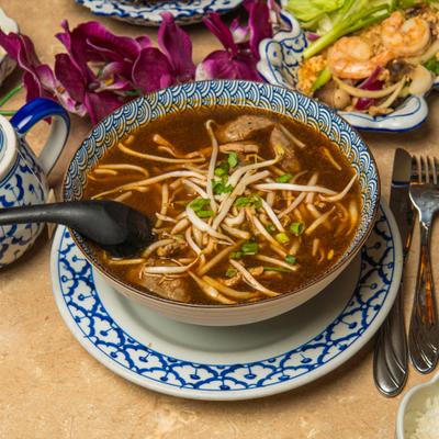 Beef noodle soup with bean sprouts and scallions.
