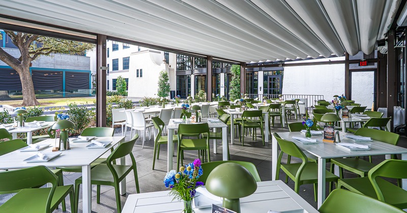 Spacious, modern and cozy enclosed patio with set dining tables