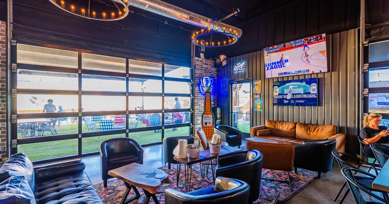 Lounge area with leather armchairs and coffee tables beside a large window
