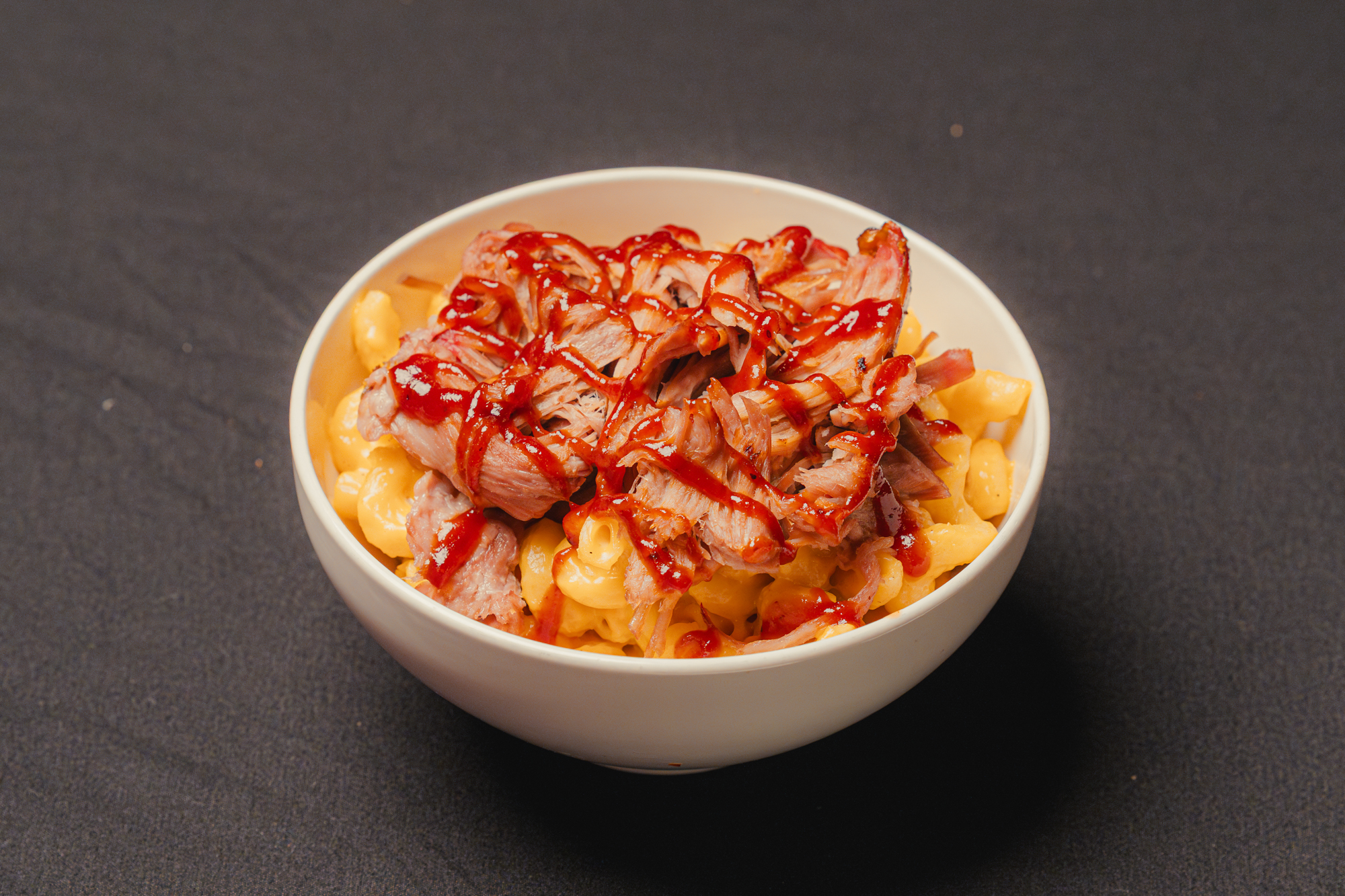 Mac n’ cheese topped with smoked chicken or pork