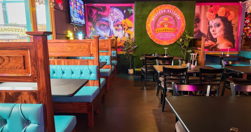A colorful interior - wooden booths, turquoise seats, Day of the Dead murals