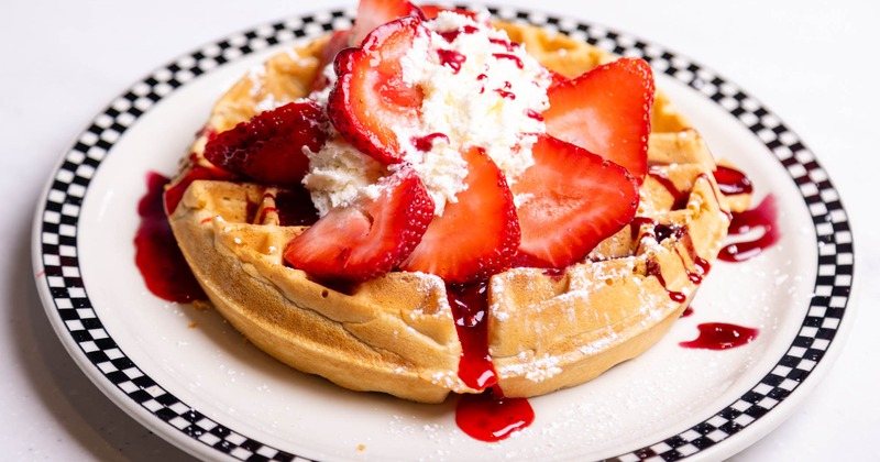 Belgian waffle with strawberries and whipped cream