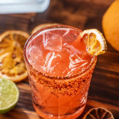 Diablito cocktail with ice, spiced rim, and dehydrated orange garnish.