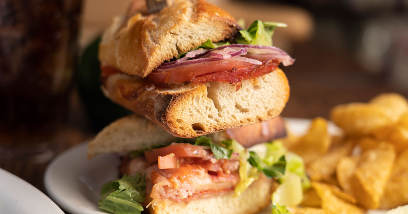 Two sandwiches, snacks on the side