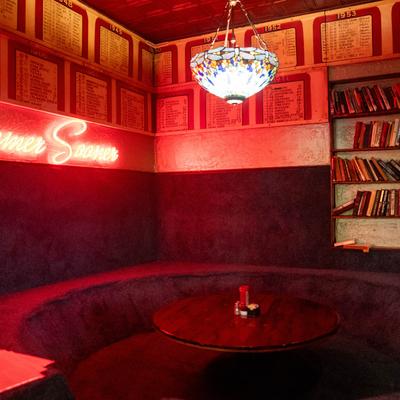 Circular booth, neon sing, stained-glass pendant light.