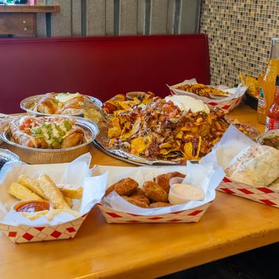 A table filled with assorted Mexican dishes and soda drinks.
