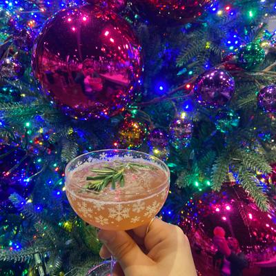 A hand holding a drink, Christmas decorations