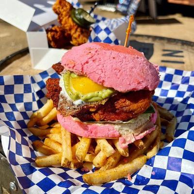 Avocado and egg fried chicken sandwich on a concha bun, served with fries