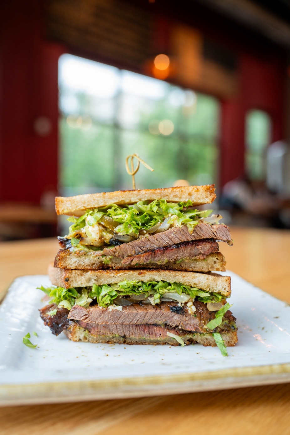 Smoked Brisket Sandwich- avocado salsa, grilled onions, pickled jalapenos, Queso Fresco and shredded lettuce