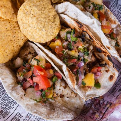 Tacos topped with pico de gallo and served with chips, top view.