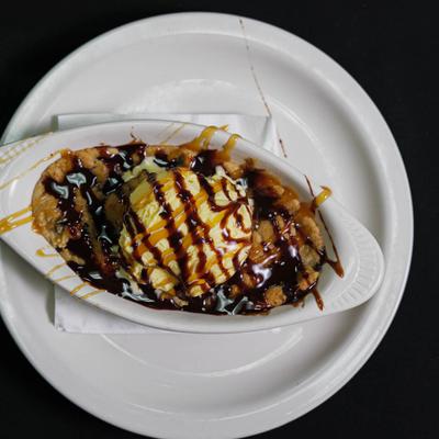 Cookie dough with ice cream, caramel, and chocolate drizzle.