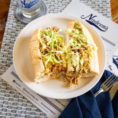 Chicken cheesesteak sandwich with lettuce.