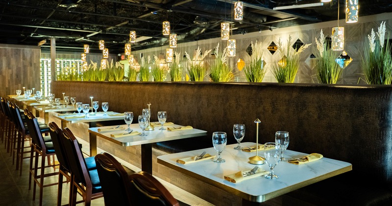 Modern and cozy interior dining area with lined up tables set for four guests