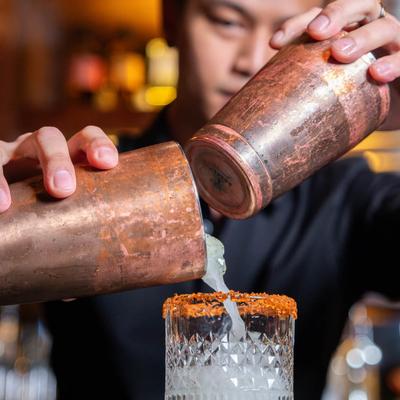 Bartender pouring a cocktail.