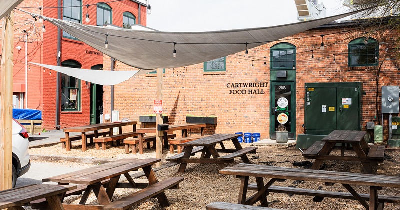 Patio, wooden tables with benches and sun shades