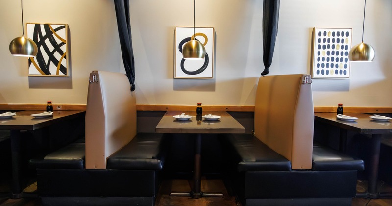 Restaurant interior with two booths, pendant lights and abstract wall art.