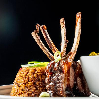 Blackened Marinated Lamb Chops, served with fried rice, and roasted brussels sprouts.