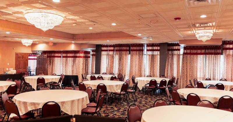 Banquet room with round tables covered with white cloths